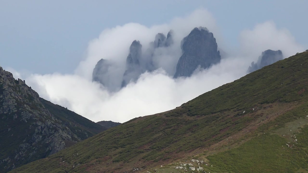 Nuvole che si muovono sopra vette montuose frastagliate