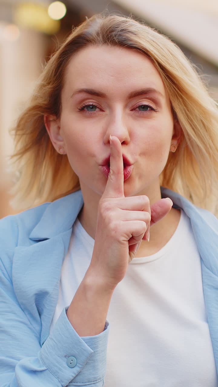 Donna signora preme l'indice sulle labbra fa silenzio silenzio gesto segno non dice pettegolezzo segreto