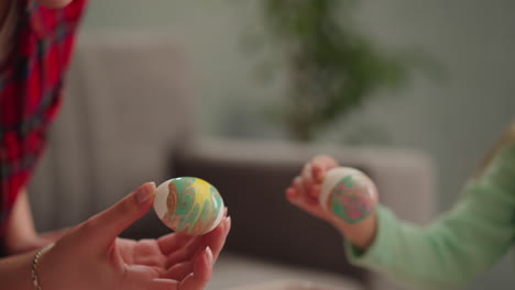 mother and little daughter hold eggs with marbling decor