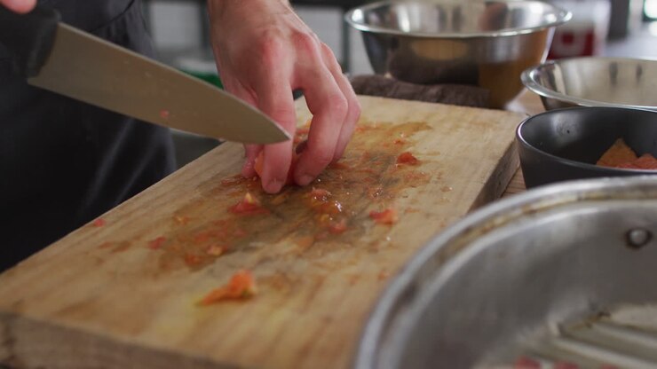 Chef uomo caucasico che taglia verdure