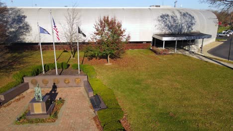 veterans memorial plaza with flag display and civic building in flat rock