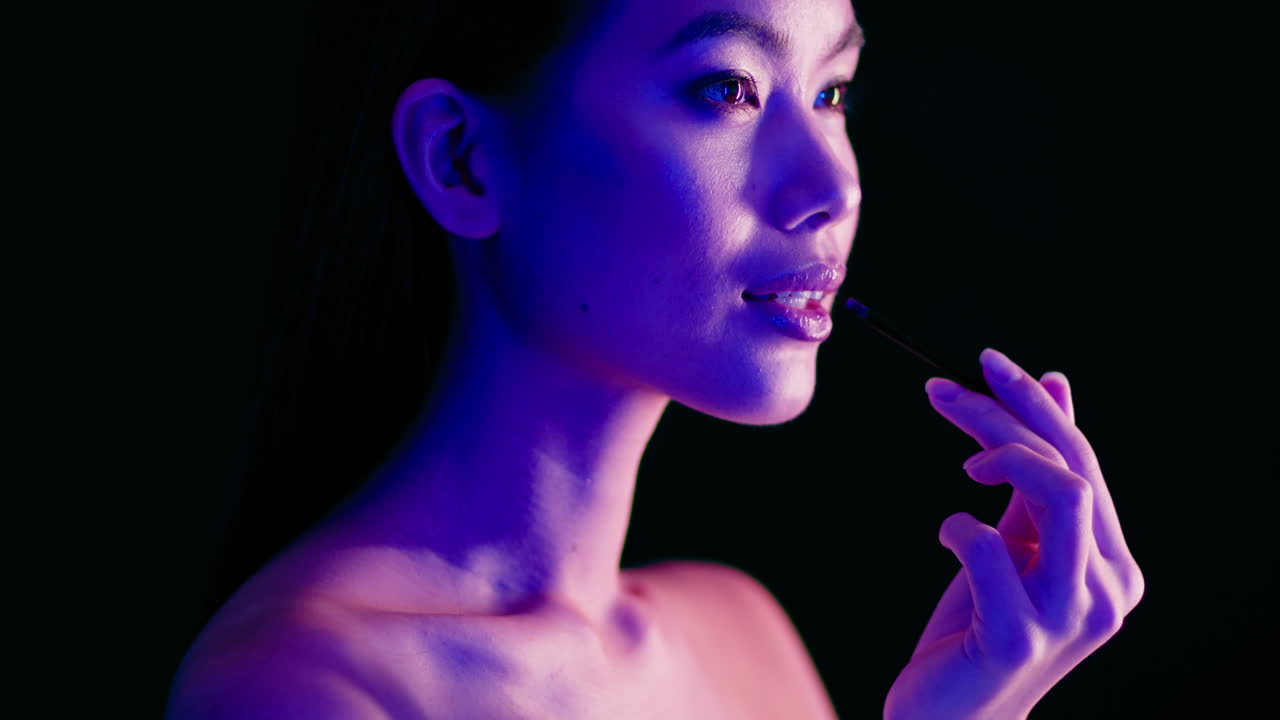Woman Applying Lipstick in Neon Light