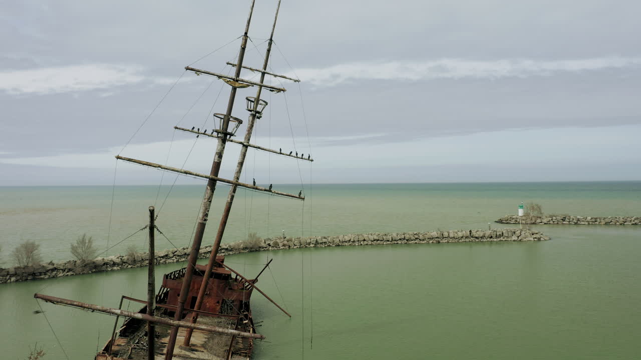 Rusty red shipwreck stuck in shallow green water