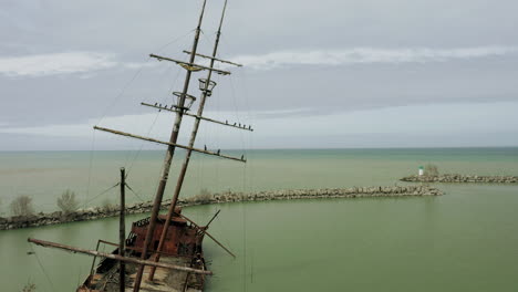 Rostiges-Rotes-Schiffswrack-Steckte-Im-Seichten-Grünen-Wasser-Fest