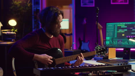 portrait of artist recording tunes on daw software with his guitar