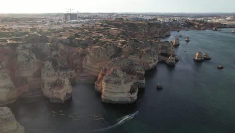 aerial footage from flying drone of tourist yachts on clear blue water in lagos, portugal