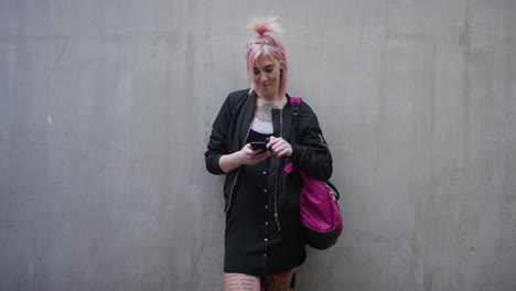 portrait young caucasian woman pink hair using smartphone texting enjoying browsing sms messages on mobile phone communication app slow motion