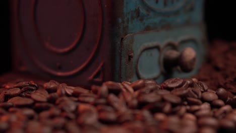 molino de café manual rústico de época, granos tostados y café molido fino macro de cerca