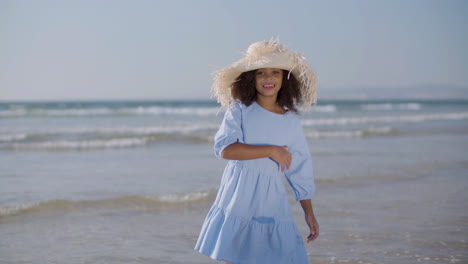 Chica-Feliz-Con-Sombrero-De-Paja-Y-Vestido-Azul-Bailando-En-La-Playa