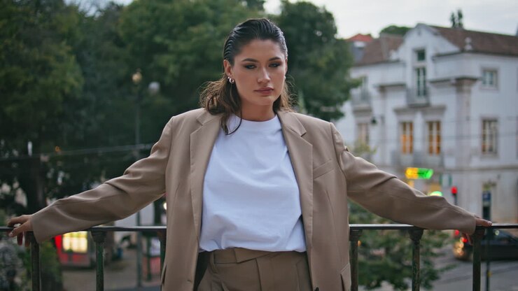 Splendida bruna che guarda in camera e si rilassa in una città di sera, da sola, primo piano