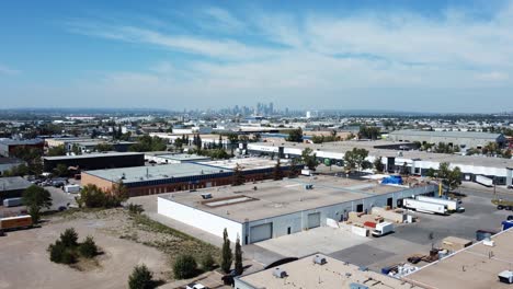 Drone-Rocket-Shot-Revealing-Calgary-Downtown-with-Warehouses-in-the-Foreground-in-Summertime