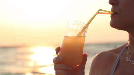 mujer bebiendo un cóctel refrescante al atardecer