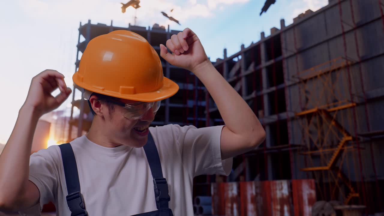 un trabajador asiático bailando en un sitio de construcción.