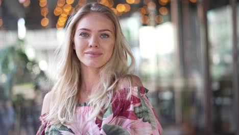 smiling blonde woman in a floral dress