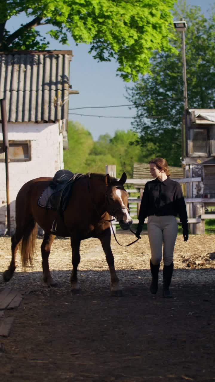 Woman leading a horse in a stable yard