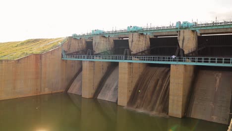 closeup of opening gates or sluice of small water reservoir or dam during afternoon