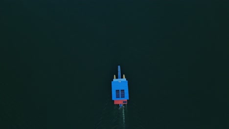 top-down aerial view of a ferry navigating the blue waters of hatillo dam, cotuí, dominican republic.