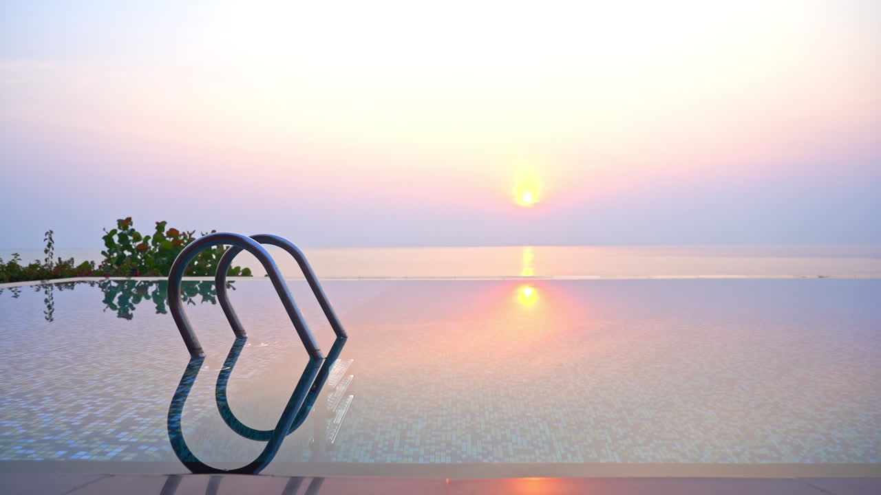 일출 시 탁 트인 바다 전망을 제공하는 빈 야외 인피니티 풀