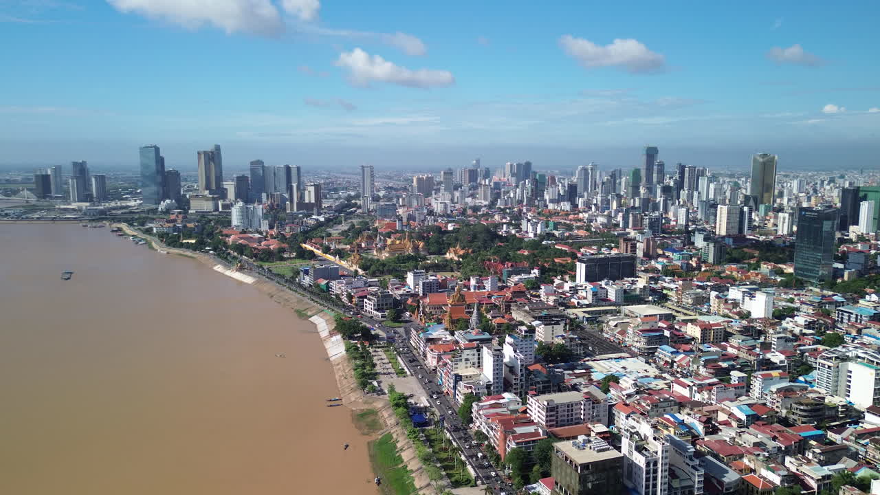Wide aerial establishing of Phnom Penh city with river and dense urban landscape in Cambodia, panoramic backdrop