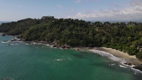 Drone-flying-away-from-the-rain-forest-at-Manuel-Antonio-National-Park,-Costa-Rica