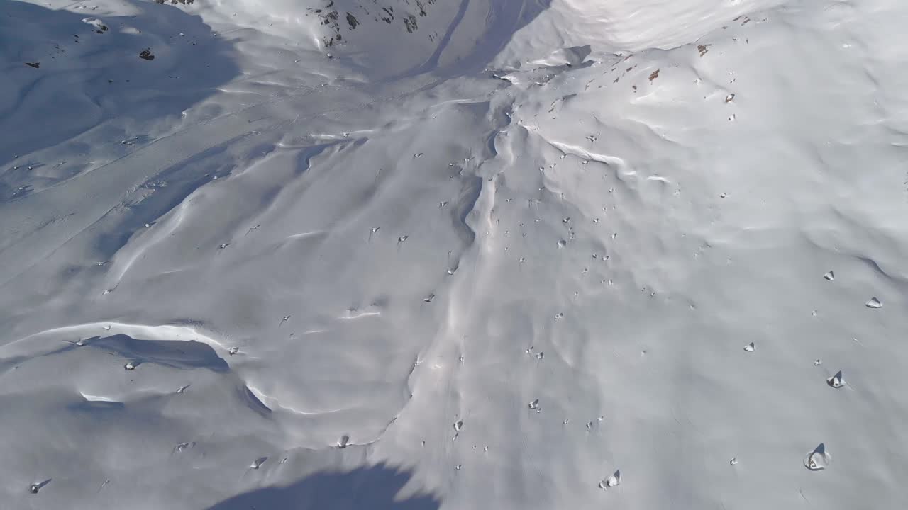 화창한 티롤 - 틸트, 드론 샷에서 눈 덮인 산 풍경이 내려다보이는 공중 전망