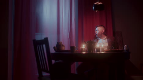 man sitting at a table in a dimly lit room