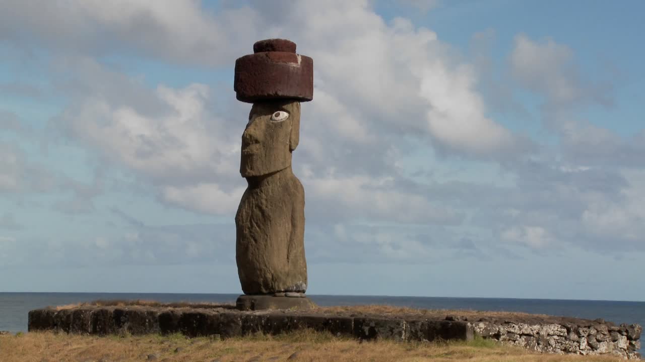 un lapso de tiempo de nubes moviéndose detrás de una estatua de la isla de pascua