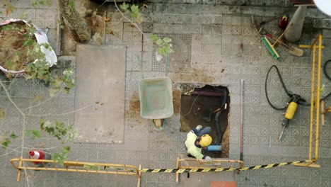 Top-View-Of-Constructor-Worker-Digging-Shoveling-and-Breaking-a-Concrete-on-a-street-in-Barcelona