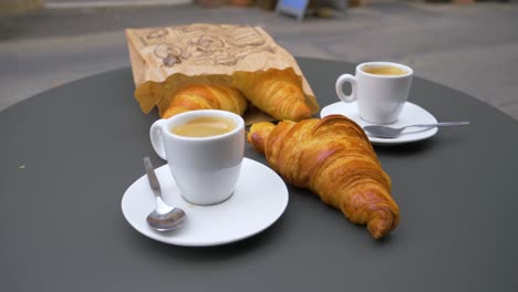 Croissants-Y-Dos-Cafés-En-Una-Mesa-Circular-De-Metal-En-La-Terraza-En-Cámara-Lenta-En-Francia-En-Un-Pueblo-Provenzal
