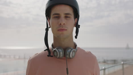 Retrato-De-Un-Joven-Se-Quita-Las-Gafas-De-Sol-Sonriendo-Con-Casco-Junto-Al-Mar