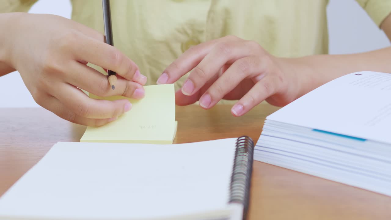 A person writes creatively in a home office setting emphasizing hands-on learning and engagement