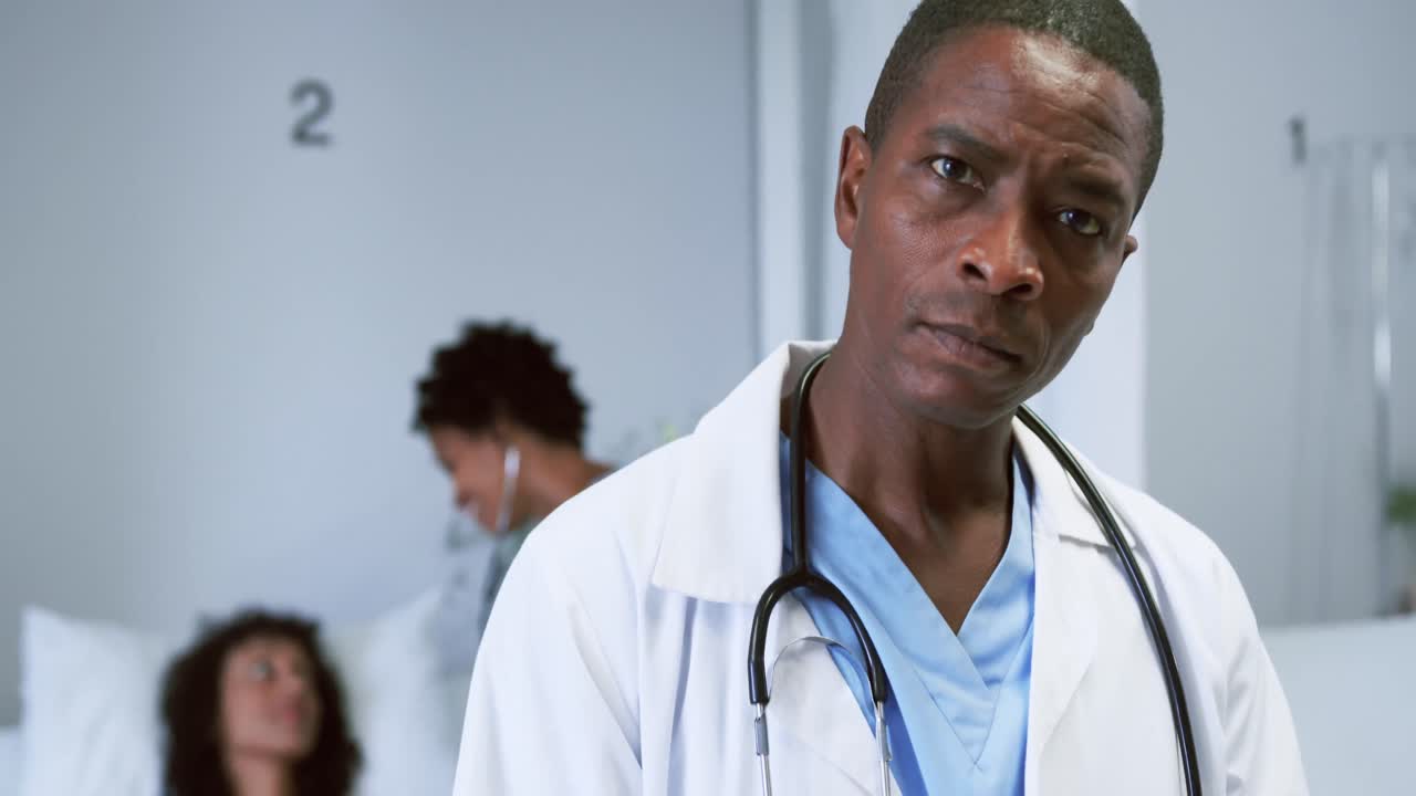 Close-up of African american doctor looking at camera while writing on clipboard in the ward 4k