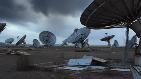 abandoned satellite dish array under a stormy sky