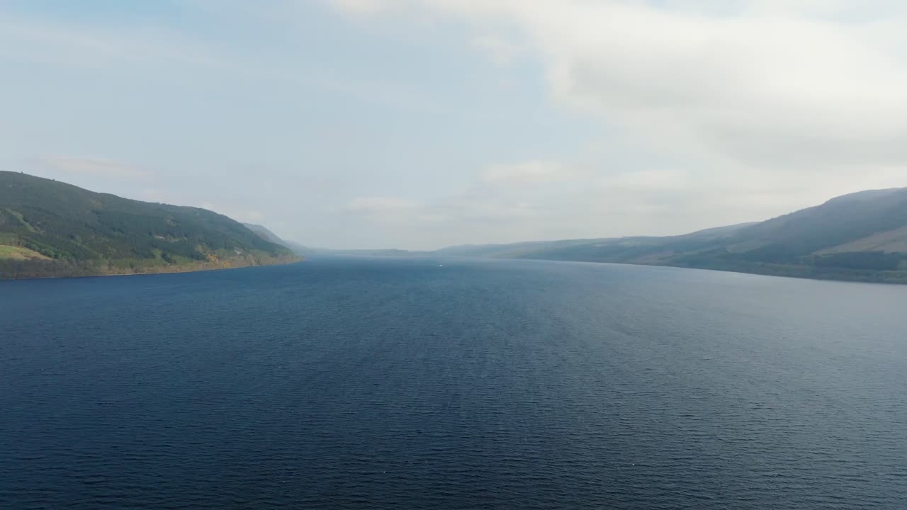 Aerial drone footage of Loch Ness, Scotland’s most famous freshwater loch, surrounded by dramatic Highland scenery. Sweeping panoramic views of the vast lake, rugged hills, and mysterious atmosphere