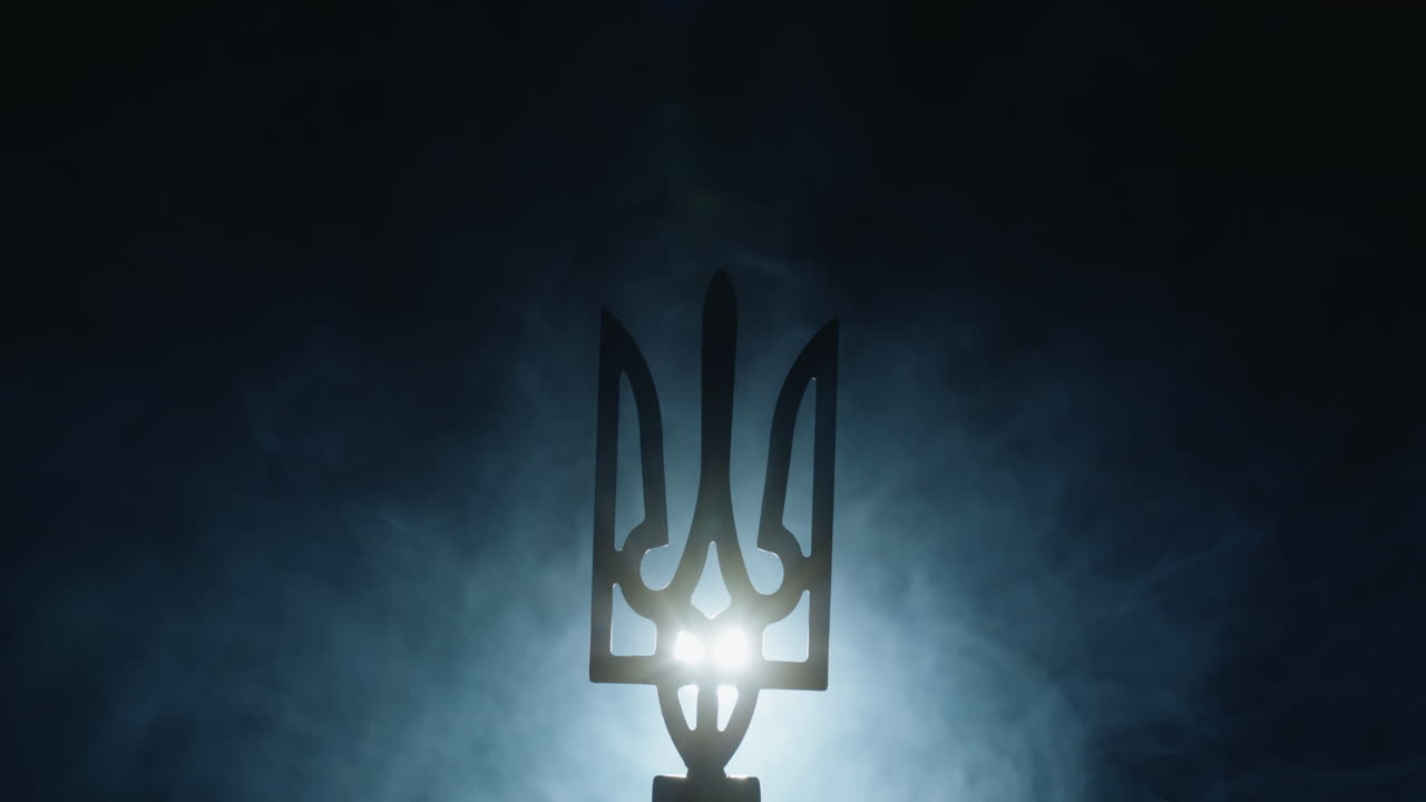 Stemma dell'Ucraina nella nebbia, illuminato da un faro