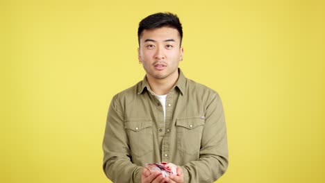joyful man celebrating with confetti on yellow background