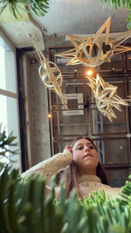 woman looking up at christmas decorations in a cafe