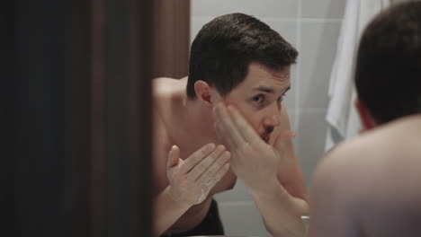 hombre lavándose la cara en el baño