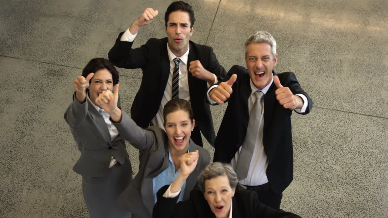 Business people cheering with thumbs up