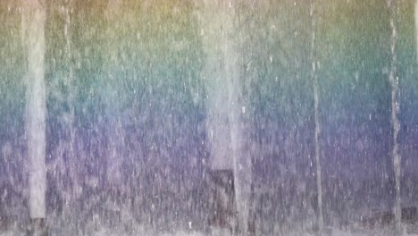 close-up view of colorful rainbow patterns forming in the mist of a fountain.