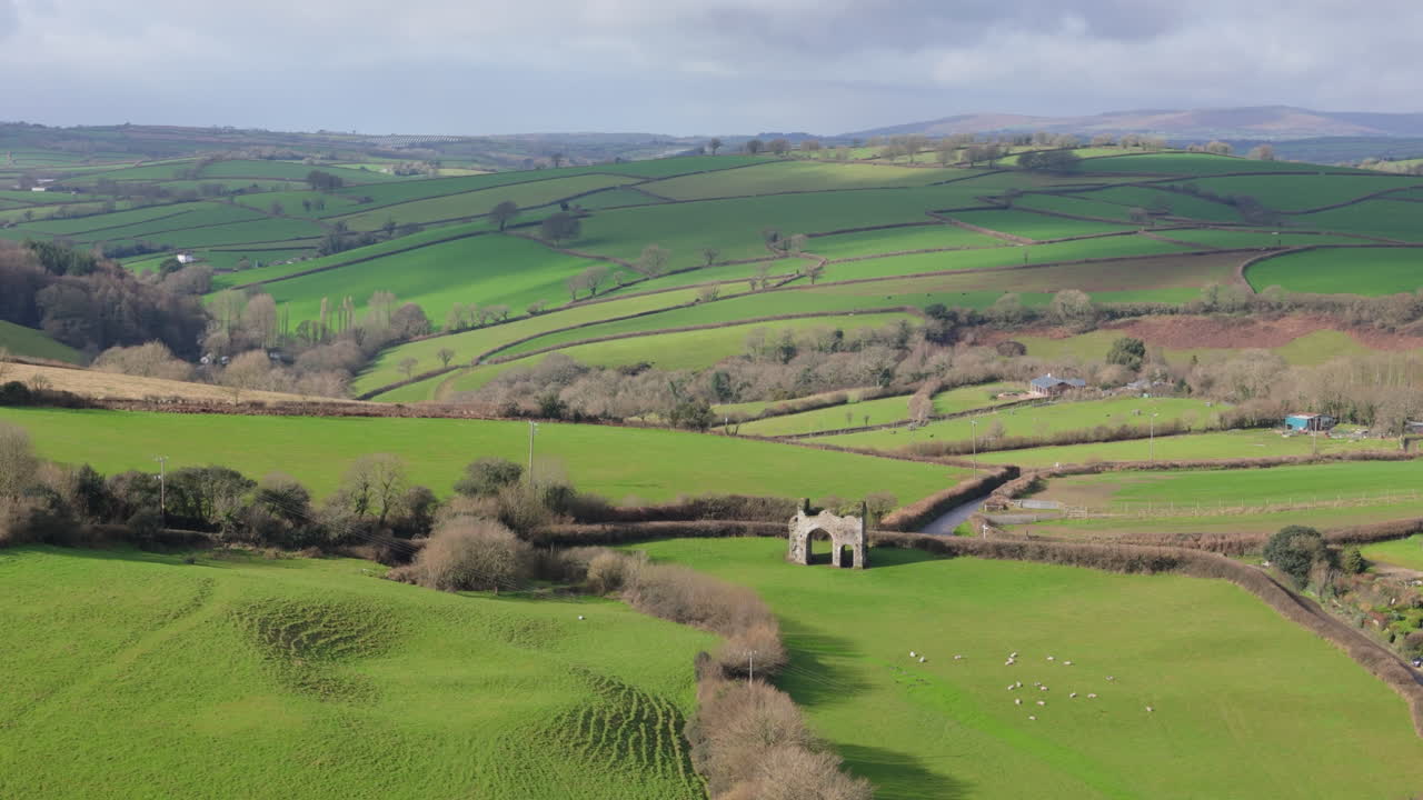 Cornworthy Priory medieval nunnery amid rolling hills in countryside, aerial