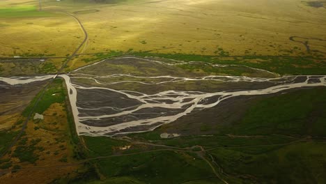 Aerial-landscape-view-of-a-glacier-river-with-many-branches-flowing-in-a-valley,-in-Iceland