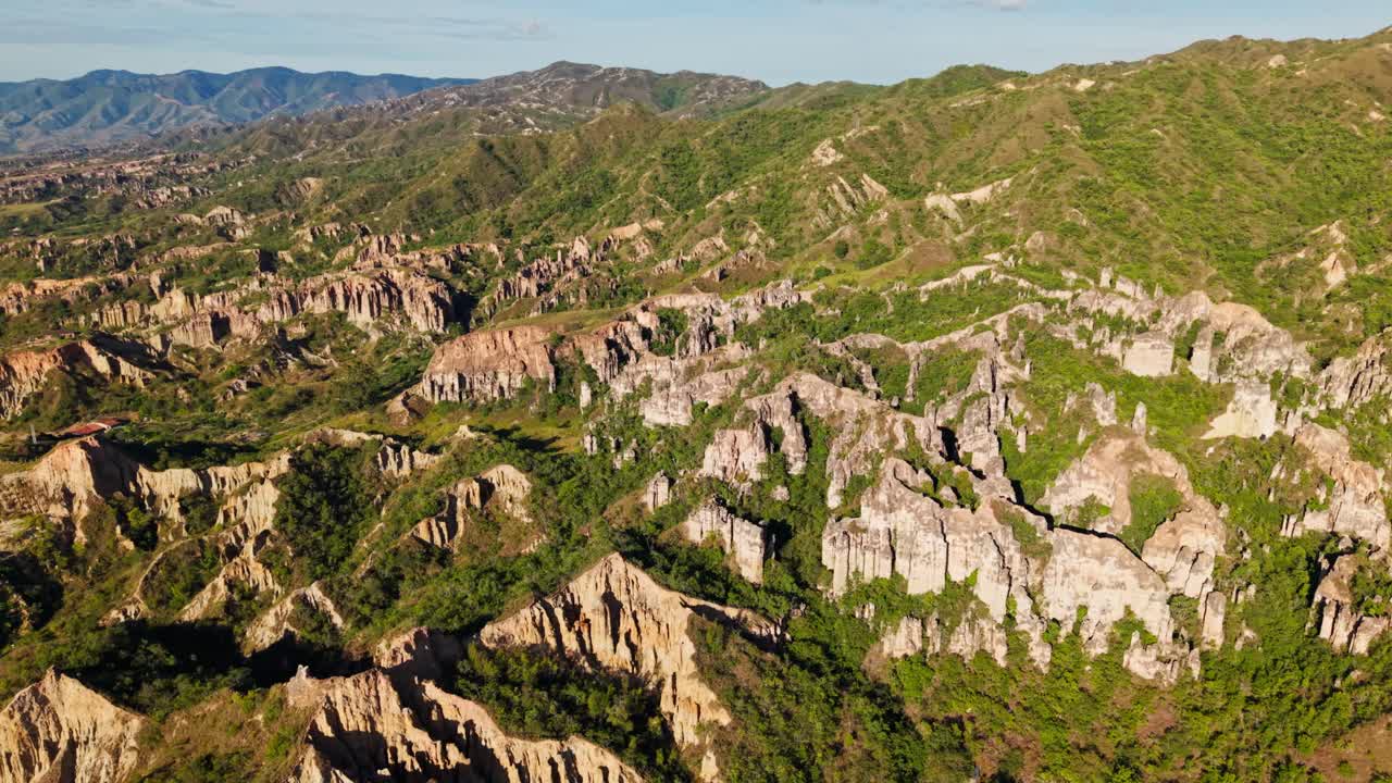Aerial sideways view of the stunning rock formations and green mountains of los estoraques in colombia