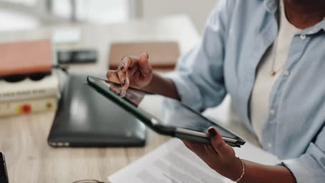 a woman uses a tablet while working at a desk