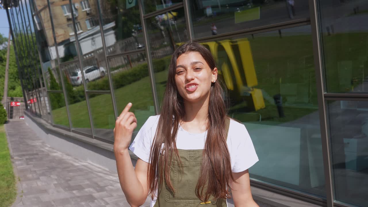 Mujer joven de pie frente a un edificio