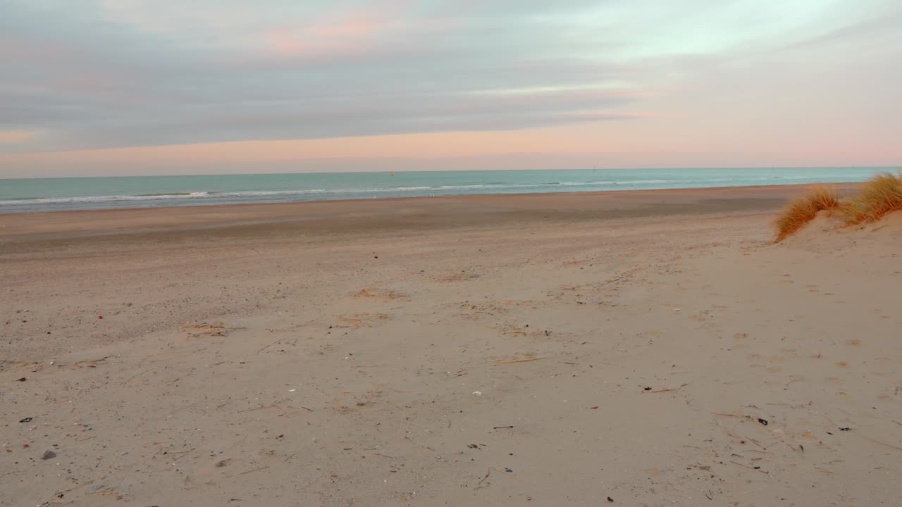 Bred sandstrand ved Dunkerque, Frankrig, kendt for sin historiske betydning og fredfyldte landskab