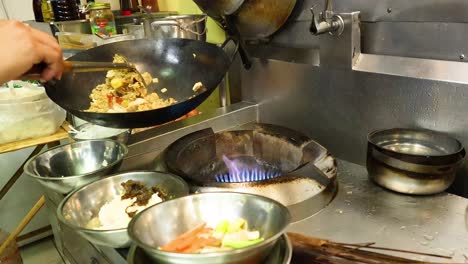 chef prepares pineapple fried rice in a wok