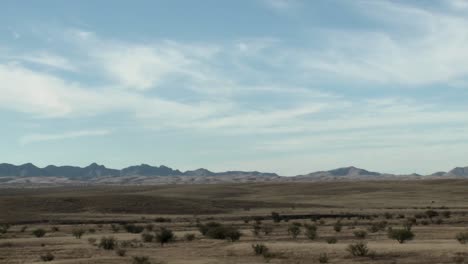 Clouds-pass-over-a-remote-area-and-cars-go-by-on-a-road-in-a-time-lapse-sequence