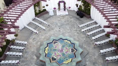 aerial top down view of a reception area of the marriage, wedding ceremony under the open sky with white folding chairs