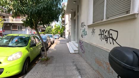 graffiti-covered alley with parked cars and trees